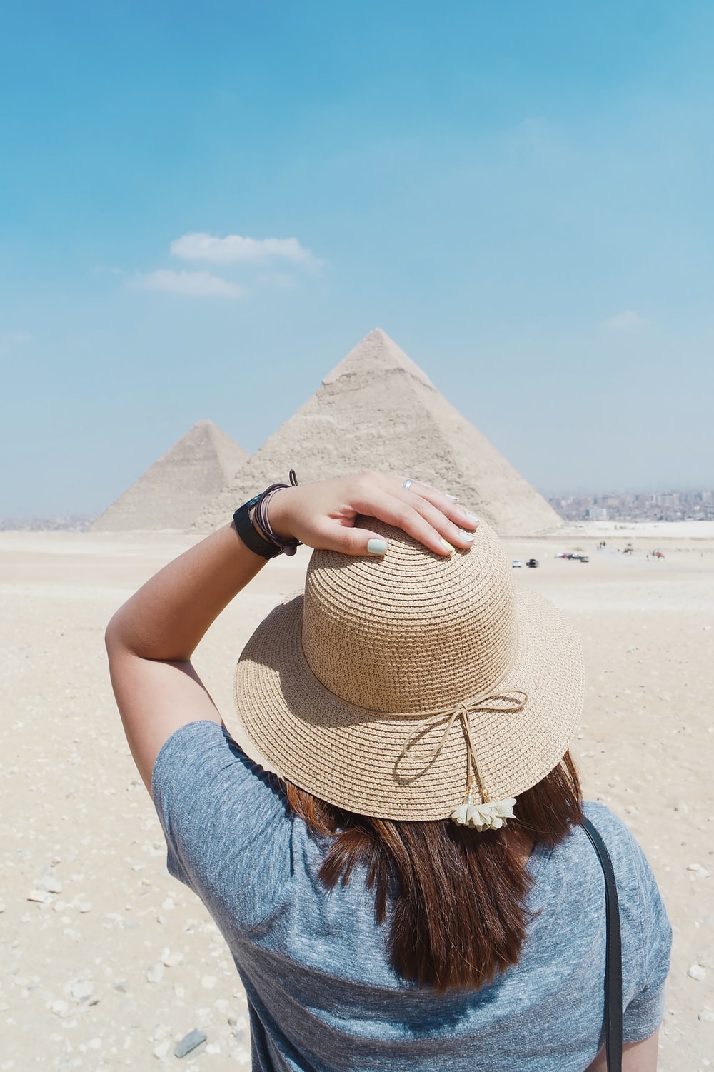 woman in blue top standing in front of Pyramid during daytime